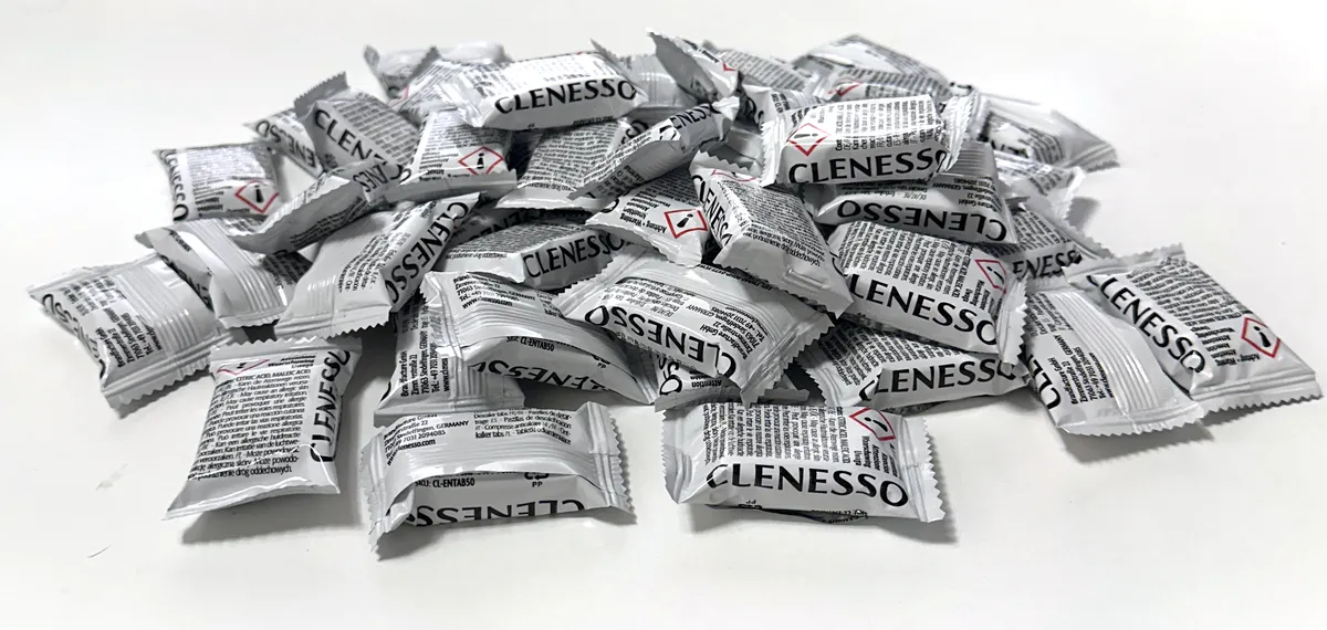 Foto der 50 CLENESSO Entkalker Tabs aus einer Packung, jeder Tab einzeln in Folie verpackt